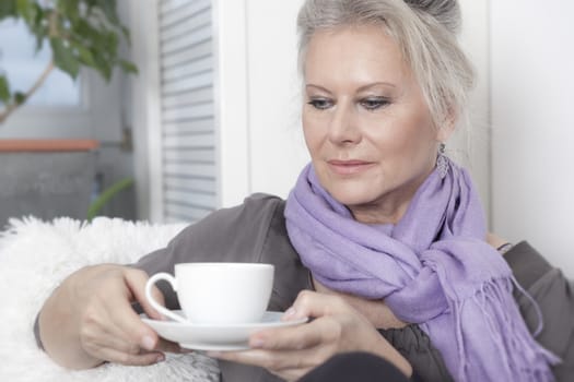 An image of a best age woman with a cup of coffee