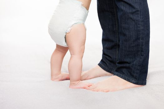 Walking toddler concept - little baby child boy making first step holding mother 