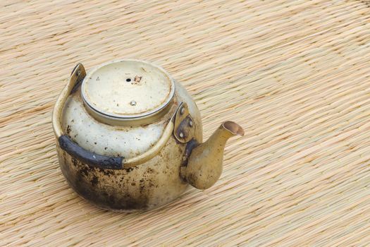 old vintage kettle on thai traditional mat