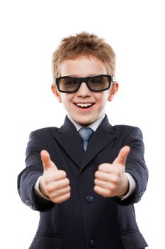 Little smiling child boy in business suit wearing sunglasses hands gesturing thumb up success sign white isolated