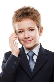 Little smiling child boy in business suit hand holding mobile phone or talking smartphone white isolated