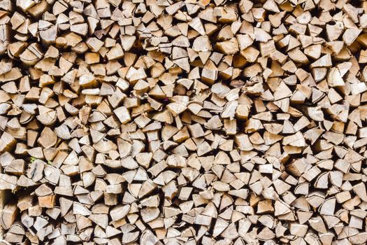 A stack of birch firewood - a natural horizontal background