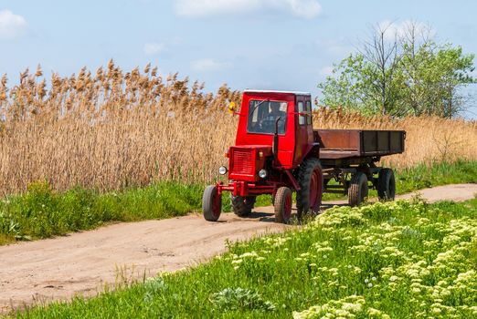 Old red tractor on the agricultural field 