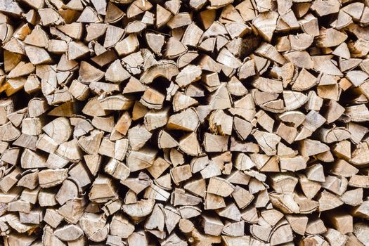 A stack of birch firewood - a natural horizontal background, close-up