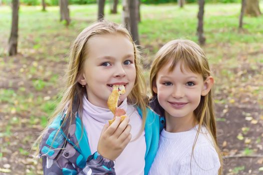 Photo of two eating girls in summer