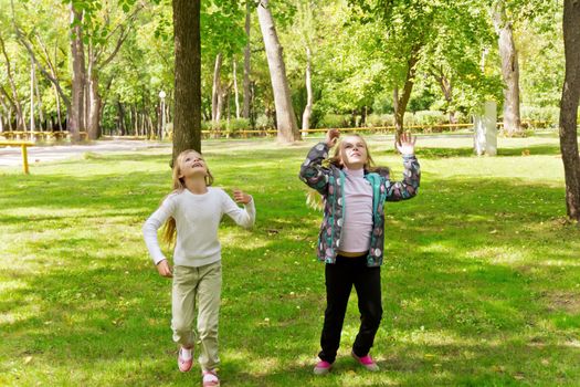 Photo of cute jumping two girls in summer