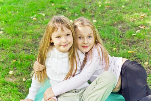 Photo of two girls sitting on grass in summer