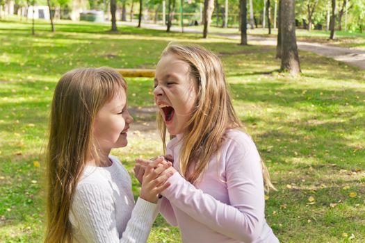 Photo of two playing girls in summer