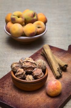 Dried peeled peach called quisa (also kisa, mocochinchi) from which a beverage is prepared with sugar and cinnamon in Bolivia. The drink is very popular and sold on the streets in Bolivia (Photographed with natural light) (Selective Focus, Focus on the front peaches)
 