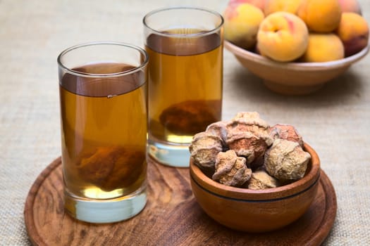 Bolivian drink called Mocochinchi made out of dried peeled peach called quisa or kisa, sugar and cinnamon. The cold drink is very popular and sold on the streets in Bolivia (Photographed with natural light) (Selective Focus, Focus on the first glass)
 