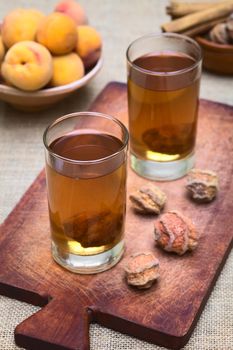 Bolivian drink called Mocochinchi made out of dried peeled peach called quisa or kisa, sugar and cinnamon. The cold drink is very popular and sold on the streets in Bolivia (Photographed with natural light) (Selective Focus, Focus on the front rim of the first glass)
 