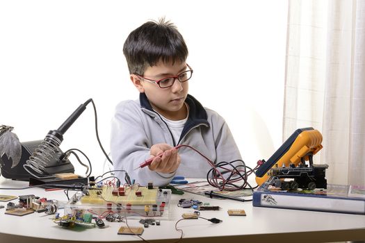 Young student performs experiments in electronics and dreams of the future.