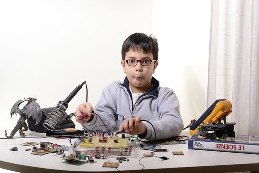 Young student performs experiments in electronics and dreams of the future.