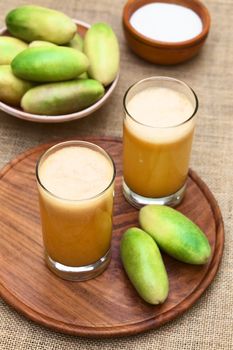 Fresh juice made of the Latin American fruit called banana passionfruit (lat. Passiflora tripartita) (in Spanish mostly tumbo, curuba, taxo) (Selective Focus, Focus in the middle of the top of the first juice)