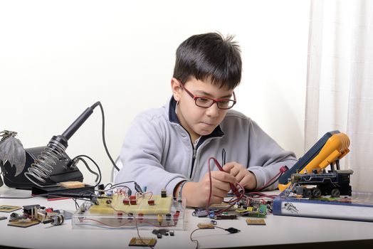 Young student performs experiments in electronics and dreams of the future.
