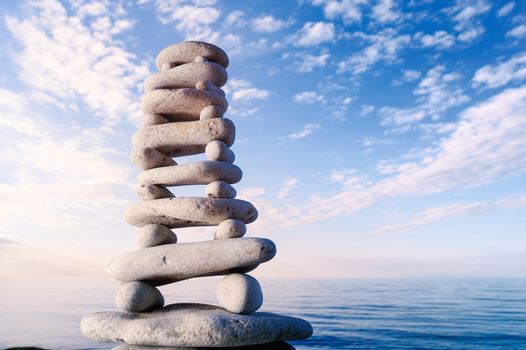 Balancing of stones each other on sky background at the sea