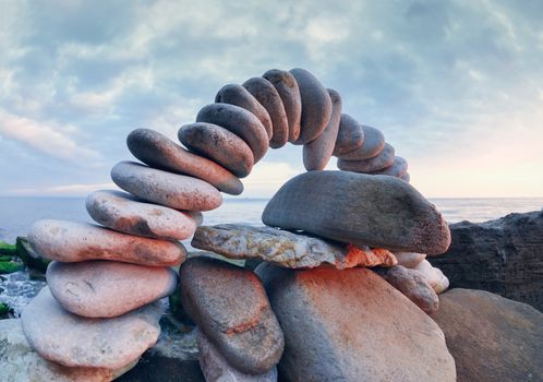 Arch of pebbles between of the stones on the coast