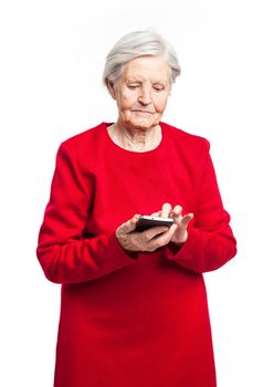 Senior woman using mobile phone while standing over white background