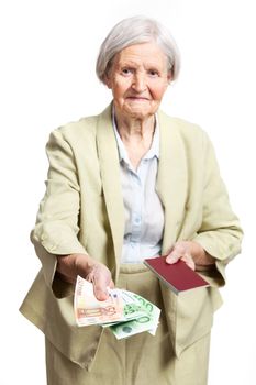 Senior woman giving money and holding passport, hand with money in focus. Isolated over white.