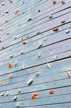 Grunge surface of an artificial rock climbing wall with toe and hand hold studs.