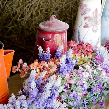 Beautiful flowers and old kettleon the wood table