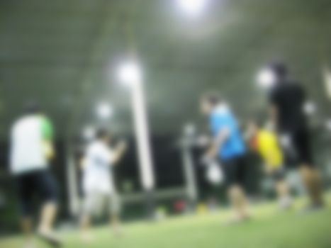 defocused men playing soccer in the field