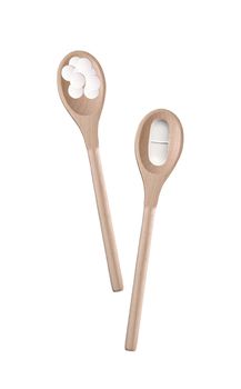 Tablets in a wooden spoon on a white background