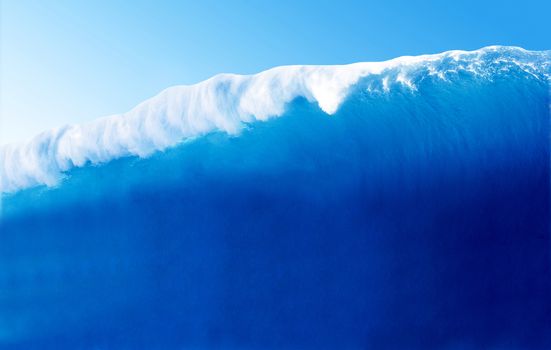 Large Blue Surfing Wave Breaks in the Ocean