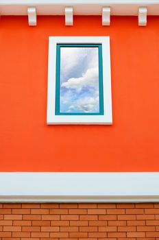 Sky and cloud reflection in window glass on orange wall of house, Italy retro style