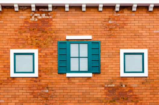 Green window on the orange brick wall outside the house in the Italy retro style
