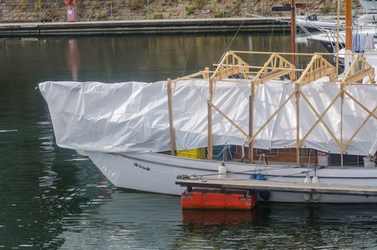 Ship renovation, repair under a tent in the harbor.