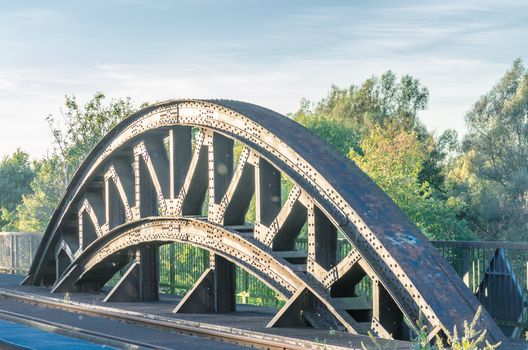 Riveted old arch of an old railway bridge.