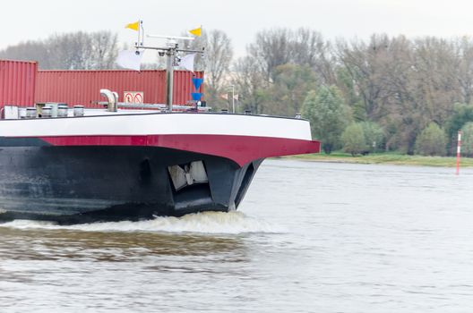 Front view of a large cargo ship at full speed.