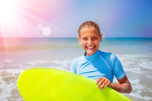 Teenage girl in blue has fun surfing