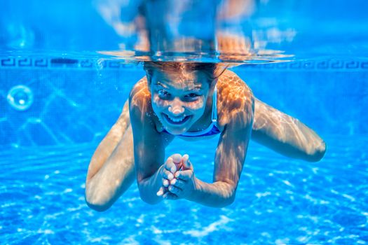 Underwater happy cute girl in swimming pool