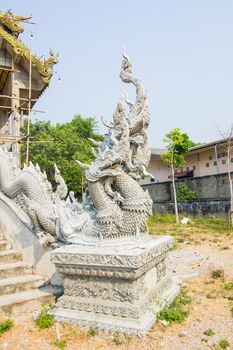 unfinished naga statue beside the stairs in Thai temple.