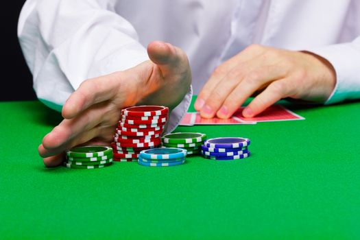 Man puts in the casino. Hand with chips closeup