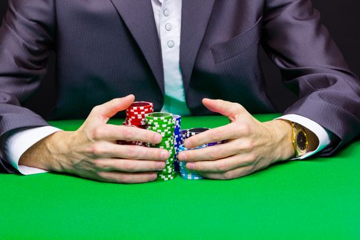 Man with a bunch of chips. Green casino table
