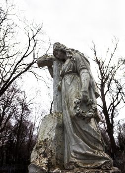 Old cemetery marble sculpture of the woman with cross