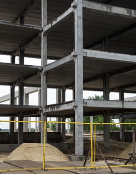 Unfinished grey concrete framework of the future building in the construction site