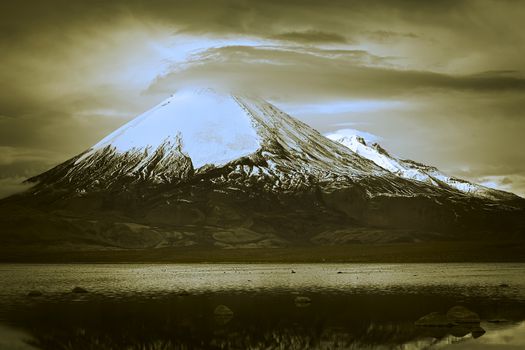 Parinacota stratovolcano (6348 meters) and Chungara Lake on the border of Chile and Bolivia on the way from La Paz to Arica. Parinacota is part of the Payachata volcanic group in Northern Chile. (Dual Toned Image)