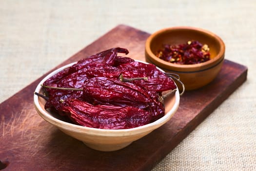 Bowl of dried (slightly hot) red aji chili pepper found in Bolivia and used for seasoning photographed with natural light (Selective Focus, Focus on the first two peppers in the bowl)