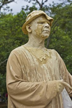 SAO PAULO, BRAZIL - FEBRUARY 01, 2015: An unidentified man executing a popular living statue performance covered with mud in one street of Ibirapuera Park at Sao Paulo Brazil.