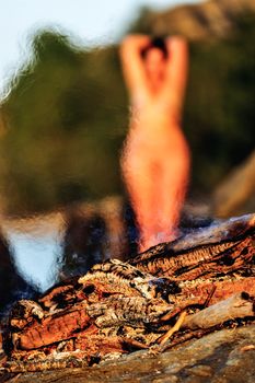 Nude woman on seashore near the bonfire