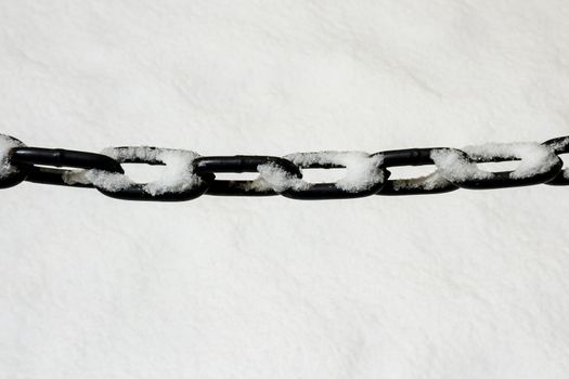 Metal chain hanging over white snow
