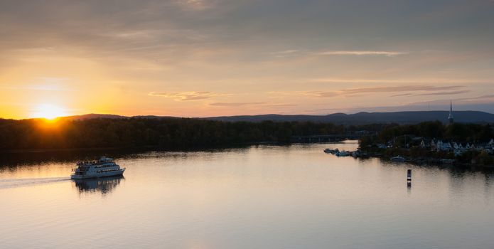 A riverboat of sight-seers cruise the river on a lovely warm summer evening