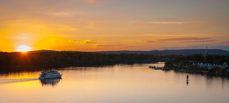 A riverboat of sight-seers cruise the river on a lovely warm summer evening