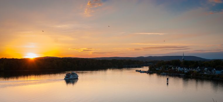 A riverboat of sight-seers cruise the river on a lovely warm summer evening