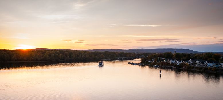 A riverboat of sight-seers cruise the river on a lovely warm summer evening