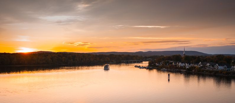 A riverboat of sight-seers cruise the river on a lovely warm summer evening